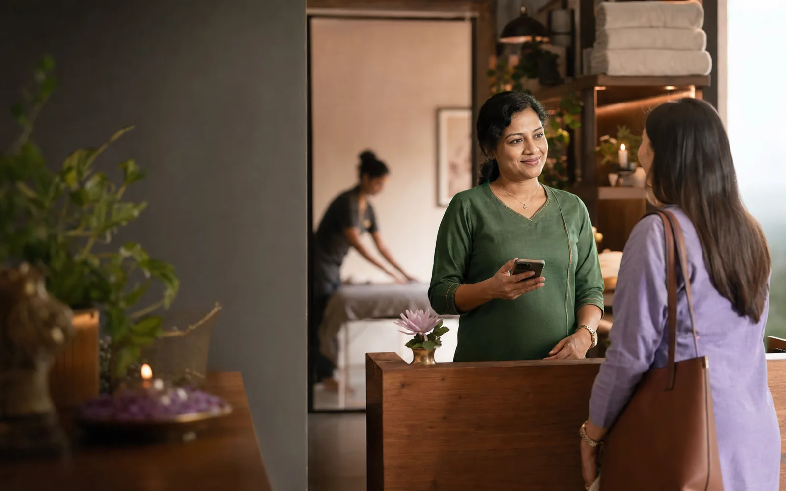 A wellness business owner welcoming a customer whose booking is already organised